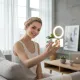 Jeune femme prenant un selfie avec une lumière annulaire LED rechargeable USB fixée sur son téléphone