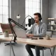 Microphone Studio Professionnel avec Bras Articulé et Antichoc pour Enregistrement et Diffusion Microphone studio professionnel avec bras articulé et antichoc métallique utilisé par un homme avec casque pour enregistrement en direct