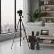 Mini trépied 25inch en aluminium installé avec appareil photo dans un salon moderne, trépied portable pliable posé à côté d'une table basse avec accessoires